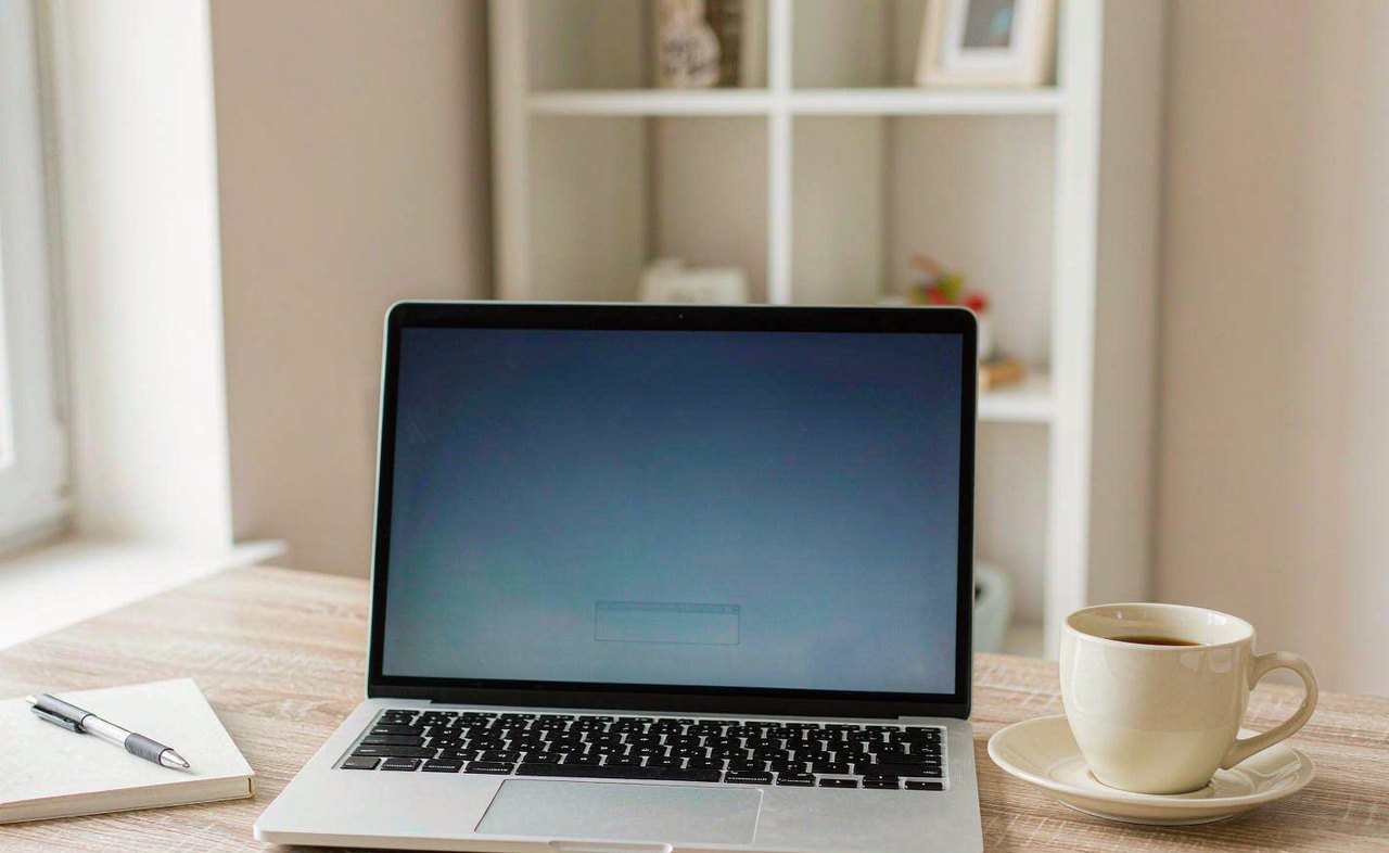 A laptop on a wooden desk showing a plain blue Windows recovery options screen